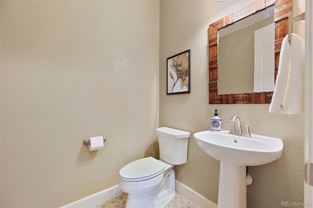bathroom with baseboards and toilet