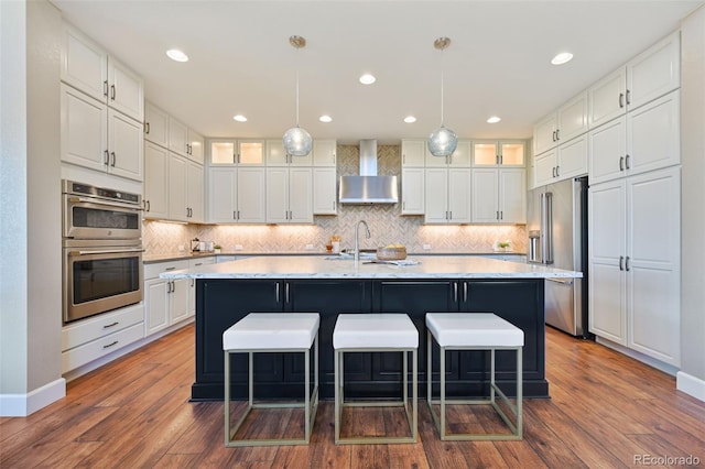 775 Woodgate Dr, Highlands Ranch, CO 80126 - kitchen featuring wall chimney range hood, appliances with stainless steel finishes, and white cabinetry