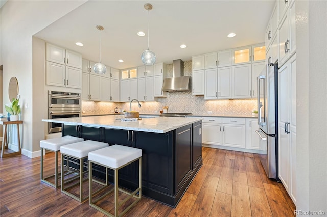 775 Woodgate Dr, Highlands Ranch, CO 80126 - kitchen featuring glass insert cabinets, white cabinetry, wall chimney exhaust hood, backsplash, and stainless steel appliances