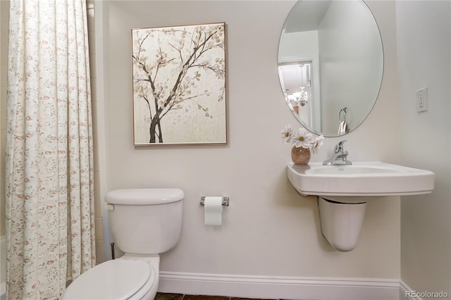 bathroom featuring a shower with shower curtain and toilet