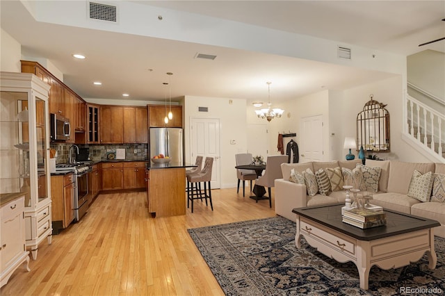 living room with a notable chandelier and light hardwood / wood-style floors