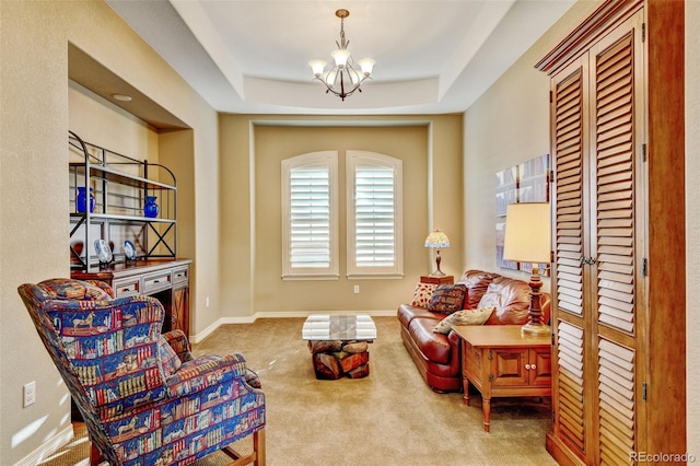 sitting room featuring a raised ceiling, carpet, and a notable chandelier