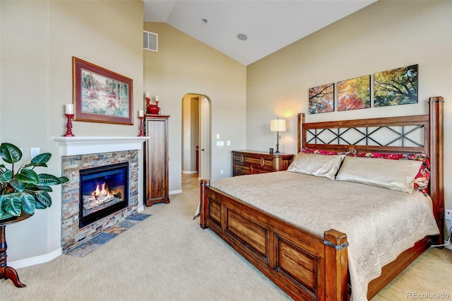 carpeted bedroom featuring a fireplace and vaulted ceiling