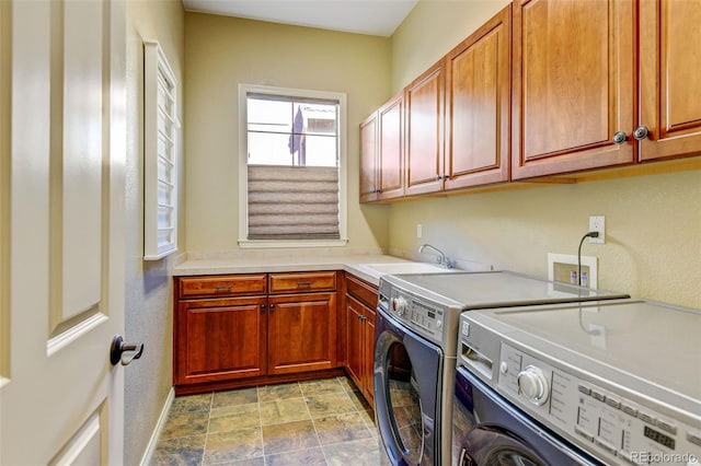 laundry room featuring cabinets, washer and clothes dryer, and sink