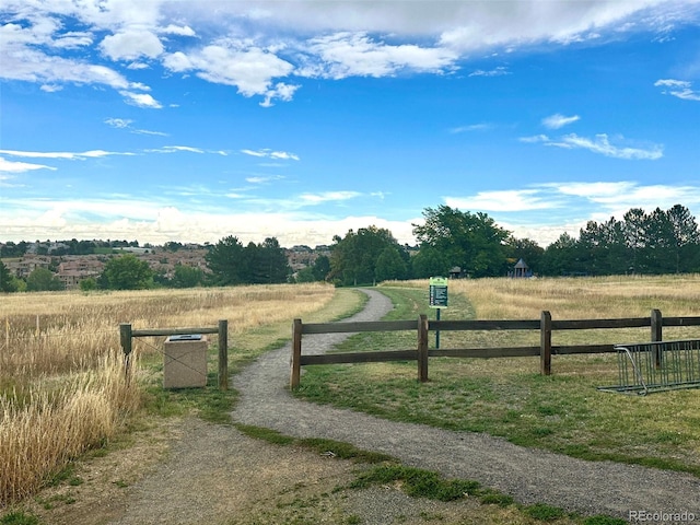 view of gate with fence and a rural view