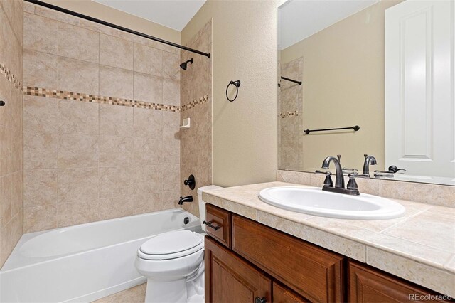 bathroom featuring shower / bathtub combination, a textured wall, vanity, and toilet