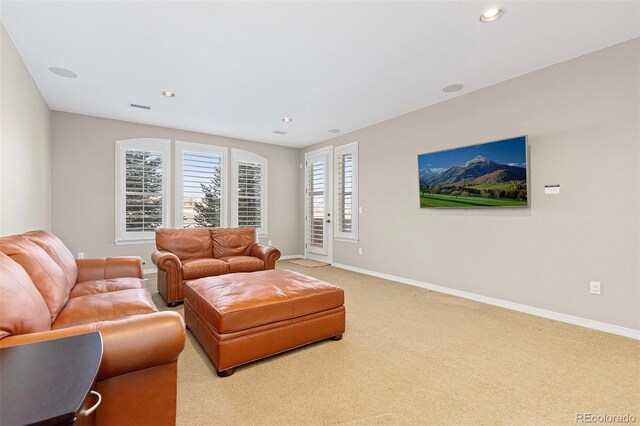 living area with light colored carpet, visible vents, baseboards, and recessed lighting