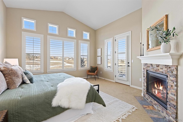 carpeted bedroom featuring access to outside, a stone fireplace, vaulted ceiling, and baseboards