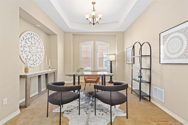 dining area featuring light carpet, a chandelier, baseboards, and a raised ceiling