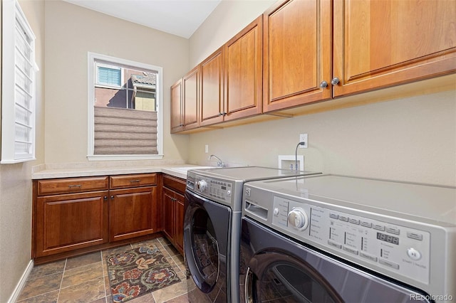 washroom with separate washer and dryer, cabinet space, baseboards, and stone finish floors