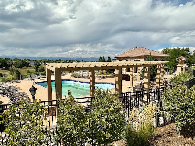 community pool featuring fence, a patio area, and a pergola