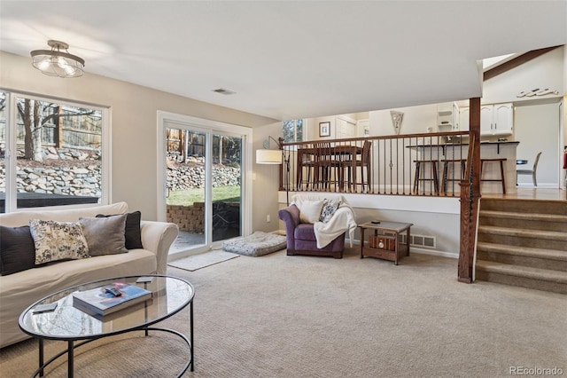 carpeted living room featuring visible vents and stairs