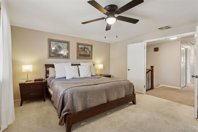 bedroom with visible vents, light colored carpet, baseboards, and ceiling fan