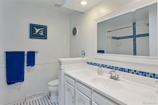bathroom featuring a wainscoted wall, toilet, vanity, and visible vents