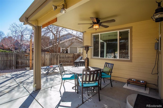 view of patio featuring outdoor dining area, a ceiling fan, and fence