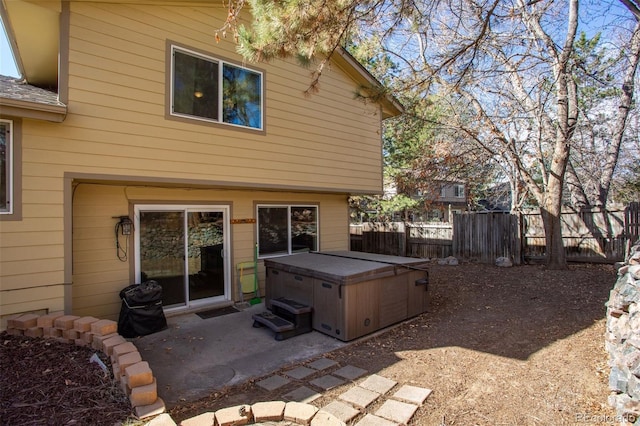 back of house with a patio, fence, and a hot tub