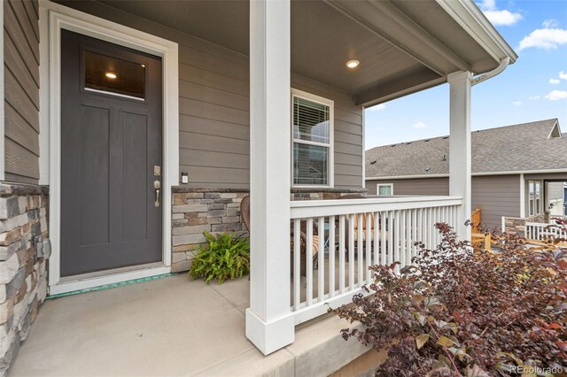 14075 Scarlet Sage St, Parker, CO 80134 - doorway to property featuring covered porch and stone siding