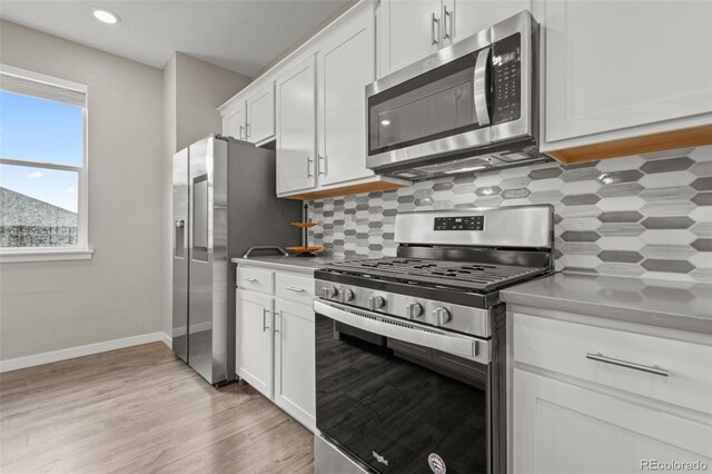 14075 Scarlet Sage St, Parker, CO 80134 - kitchen with stainless steel appliances, white cabinetry, tasteful backsplash, baseboards, and light wood finished floors