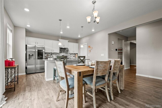 14075 Scarlet Sage St, Parker, CO 80134 - dining space featuring light wood-style flooring, baseboards, recessed lighting, and a chandelier