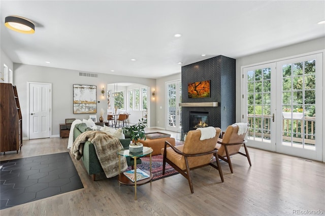 4978 Camel Heights Rd, Evergreen, CO 80439 - living room featuring a large fireplace, recessed lighting, arched walkways, and wood finished floors