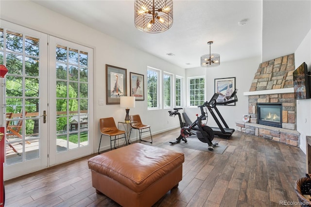 4978 Camel Heights Rd, Evergreen, CO 80439 - workout area with a chandelier, wood-type flooring, and a fireplace