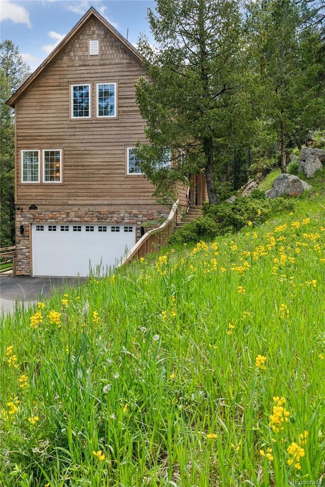4978 Camel Heights Rd, Evergreen, CO 80439 - view of side of home featuring an attached garage and driveway