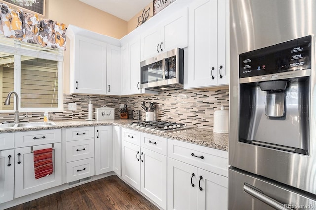 2726 Aylesbury Way, Johnstown, CO 80534 - kitchen featuring stainless steel appliances, a sink, decorative backsplash, and white cabinets