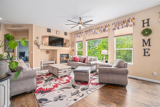 2726 Aylesbury Way, Johnstown, CO 80534 - living room with a ceiling fan, wood finished floors, a glass covered fireplace, and baseboards