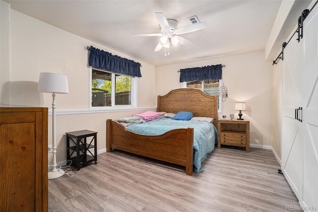 2726 Aylesbury Way, Johnstown, CO 80534 - bedroom featuring a barn door, wood finished floors, baseboards, and ceiling fan