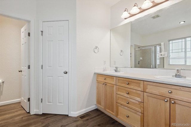 bathroom with vanity, hardwood / wood-style flooring, and a shower with shower door