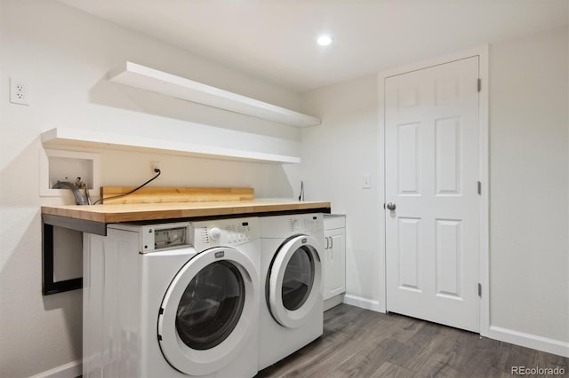 laundry room with cabinets, washer and dryer, and dark hardwood / wood-style floors