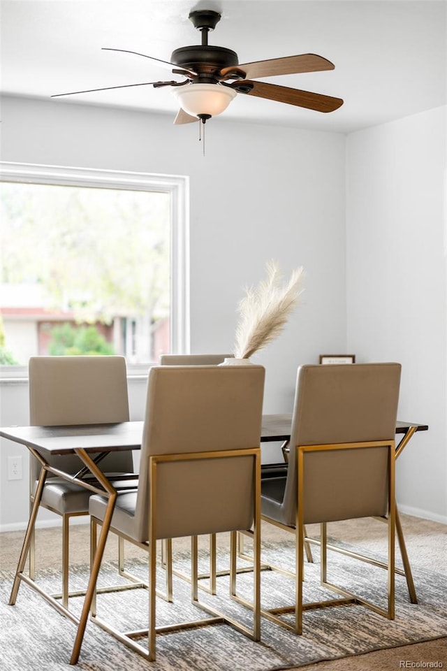 carpeted dining room featuring ceiling fan, a desk, and baseboards