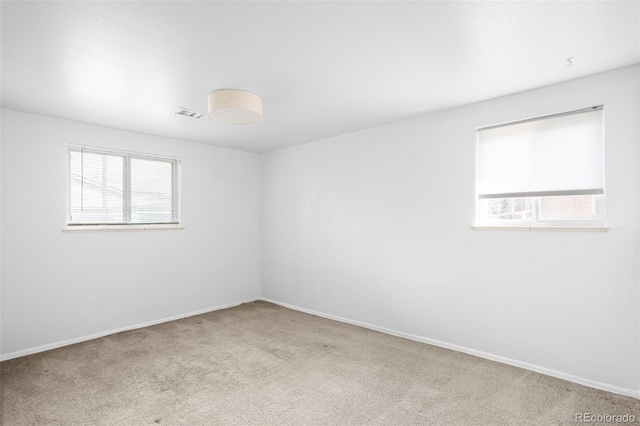 empty room with healthy amount of natural light, carpet, and baseboards