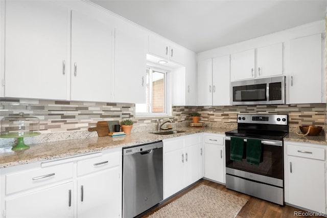 3322 Simms St, Wheat Ridge, CO 80033 - kitchen featuring stainless steel appliances, decorative backsplash, white cabinetry, dark wood finished floors, and light stone counters