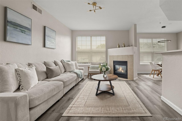 7440 S Blackhawk St Unit 2-108, Englewood, CO 80112 - living area with wood finished floors, a tile fireplace, and a chandelier