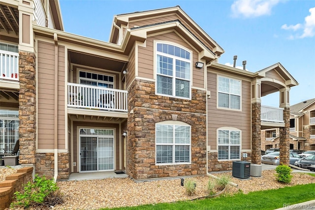 7440 S Blackhawk St Unit 2-108, Englewood, CO 80112 - back of property featuring stone siding and a balcony