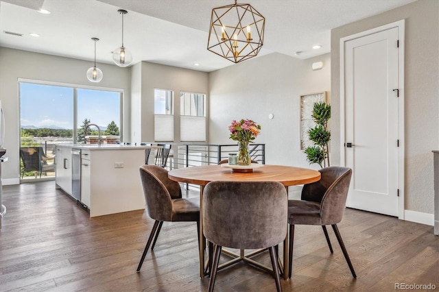 dining area with dark hardwood / wood-style flooring and a notable chandelier