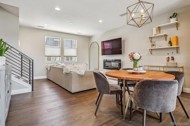 dining room with dark hardwood / wood-style flooring and a notable chandelier