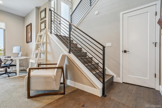 stairs with hardwood / wood-style flooring and a healthy amount of sunlight