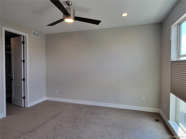 spare room with light colored carpet and ceiling fan