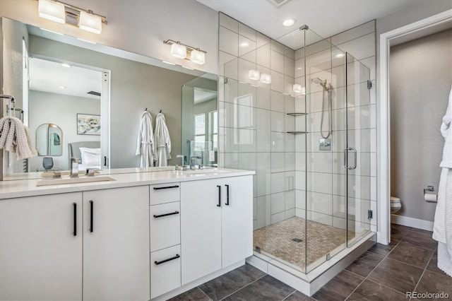 bathroom with walk in shower, tile patterned floors, vanity, and toilet