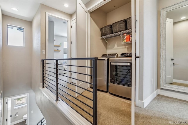 hallway featuring washer and dryer and light colored carpet