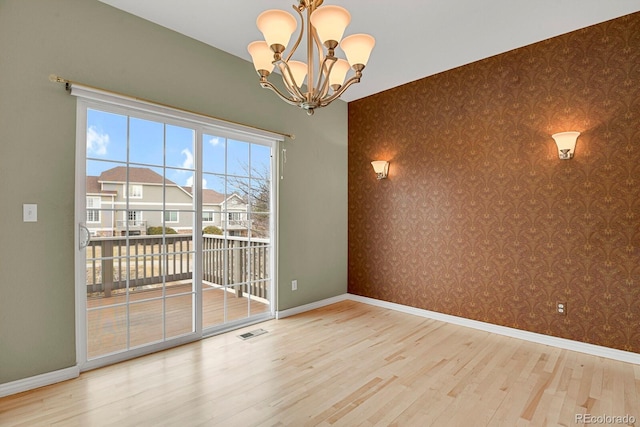 unfurnished dining area featuring a chandelier and hardwood / wood-style flooring