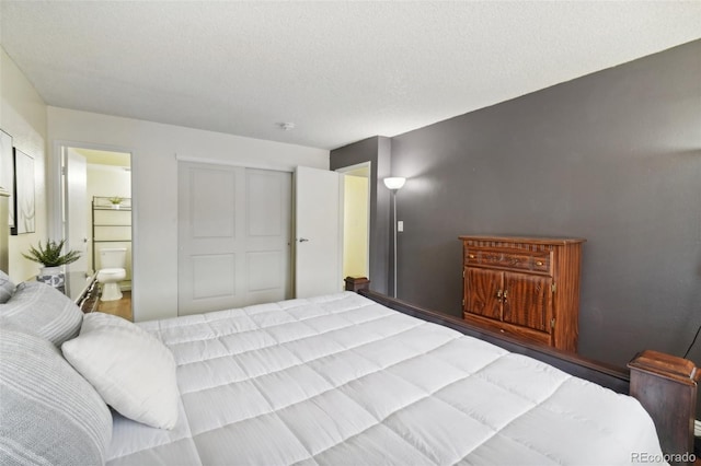 bedroom with a closet, a textured ceiling, and ensuite bathroom