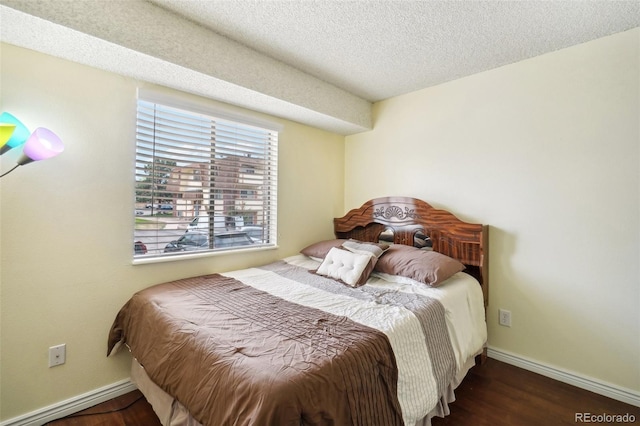 bedroom with dark wood-type flooring and a textured ceiling