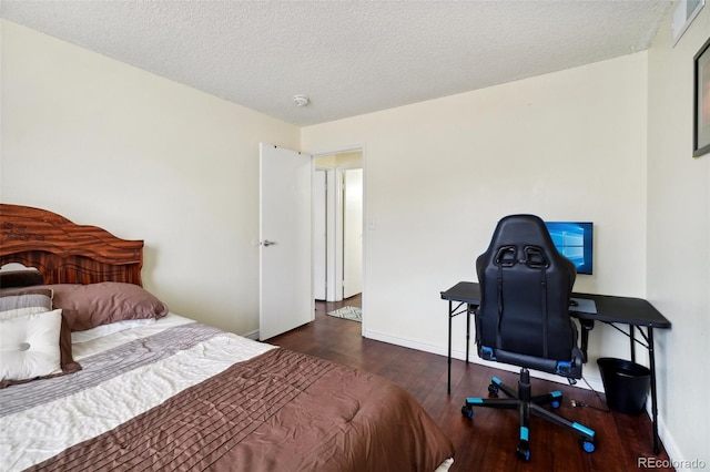 bedroom with dark wood-type flooring and a textured ceiling