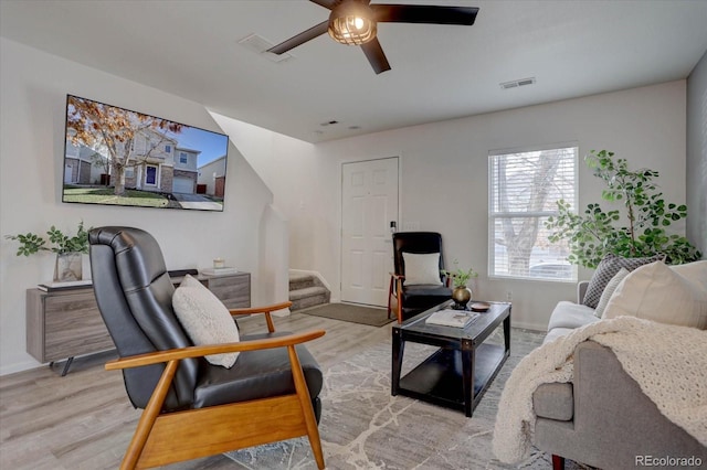 living area featuring visible vents, stairway, ceiling fan, and wood finished floors