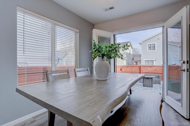 dining space featuring visible vents, baseboards, and wood finished floors