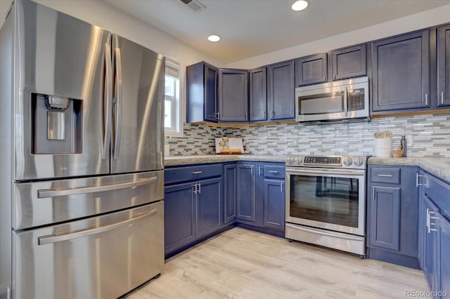 kitchen with light wood finished floors, recessed lighting, backsplash, and appliances with stainless steel finishes