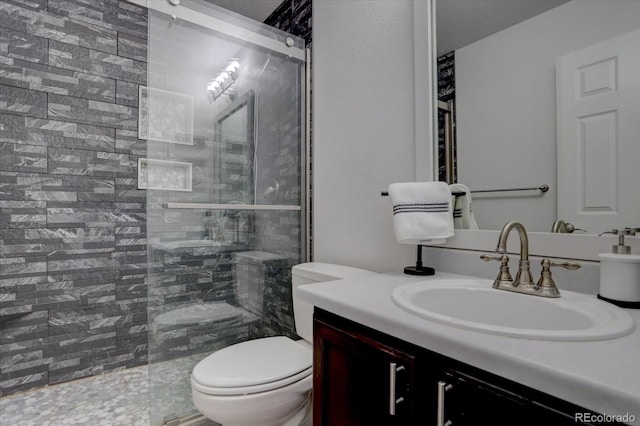 bathroom featuring vanity, toilet, and tiled shower